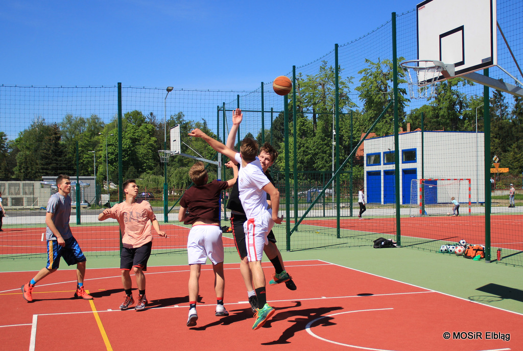 Grupa mężczyzn grają koszykówkę na boisku