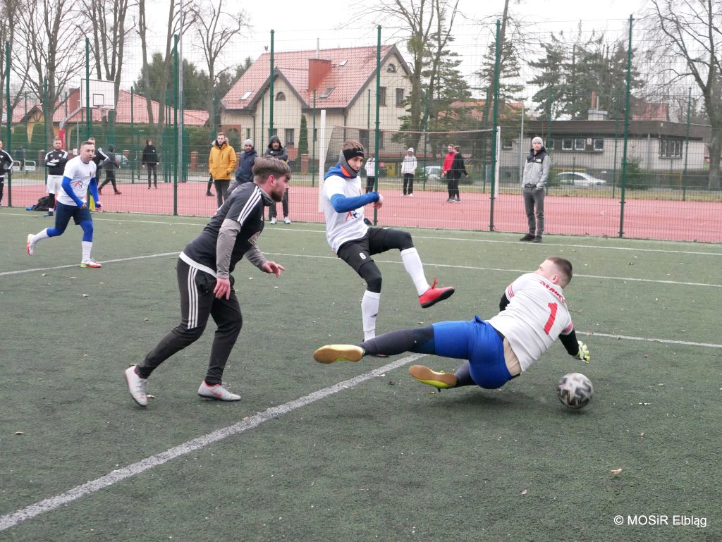 Grupa mężczyzn gra w piłkę nożną na boisku