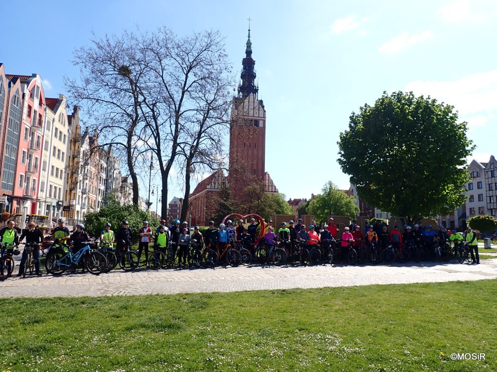 Grupa ludzi stoi przy rowerach