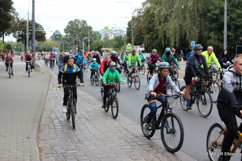 Grupa ludzi jedzie na rowerze po ulicy